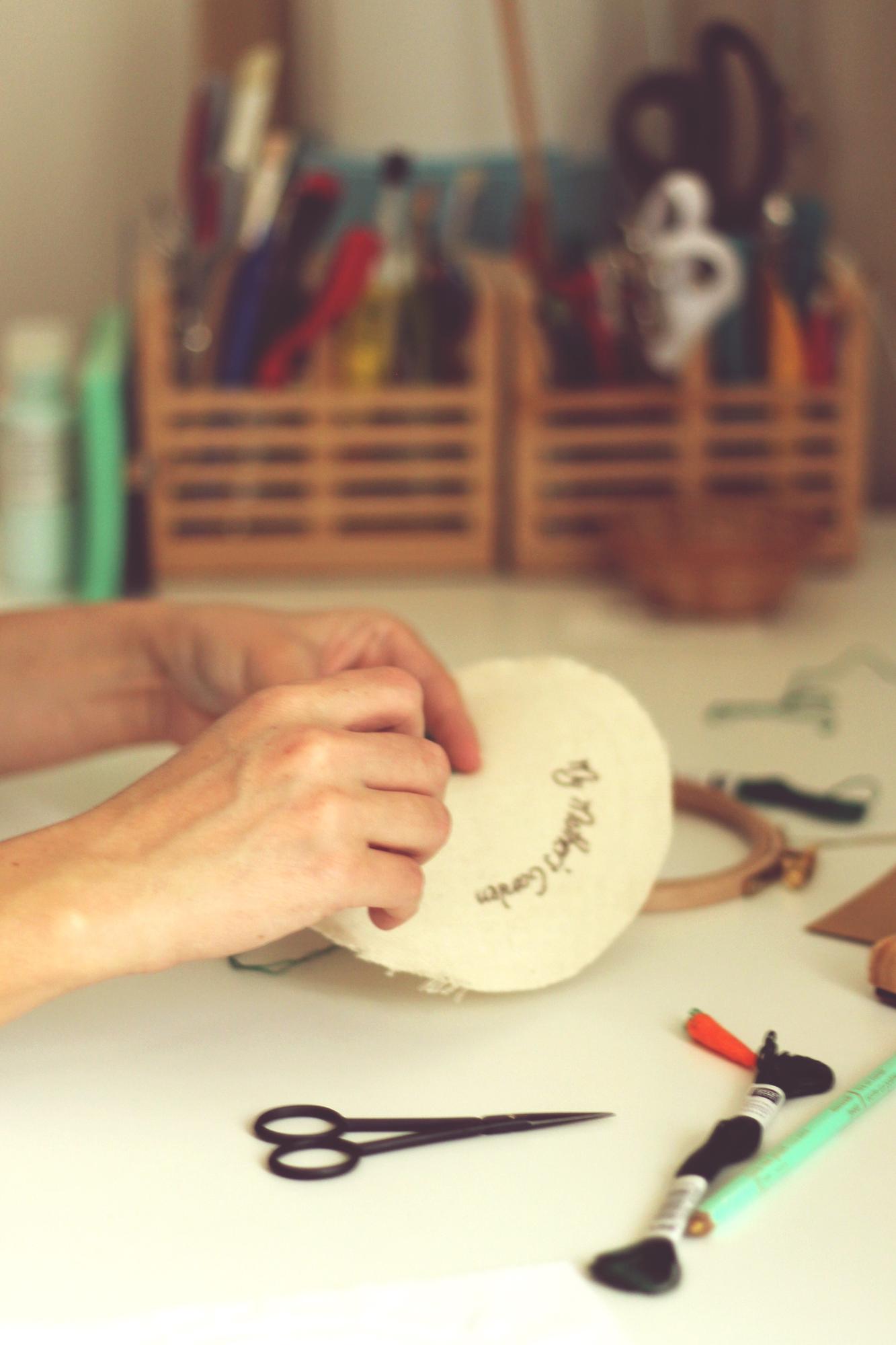 Workshop hands arranging embroidered patches